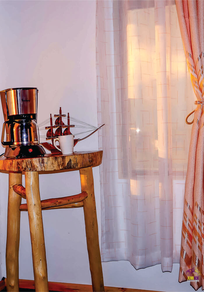 A small wooden table with coffee maker on top in a triple room on 2-night budget accommodation in Masai Mara at Lion Sands