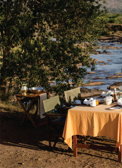Table settings near River for enjoying a unique dining experience on group accommodation in Masai Mara at Budget Lodge